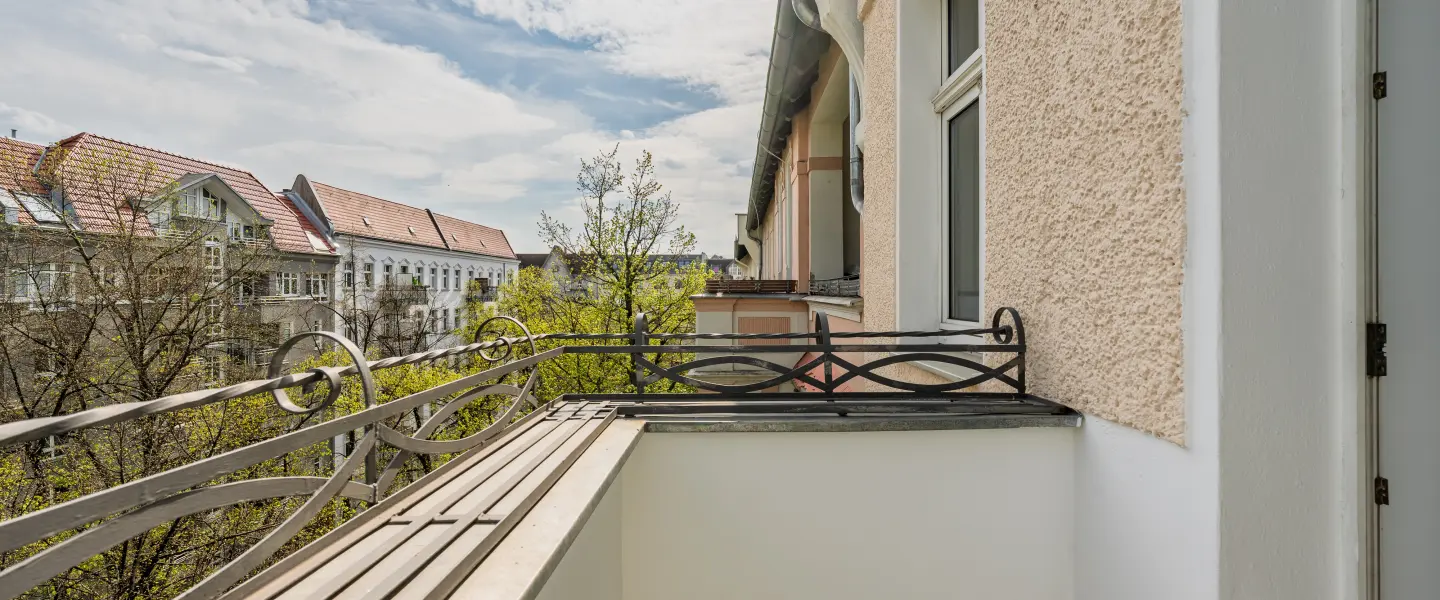 Balkon mit Blick in die begrünte Straße