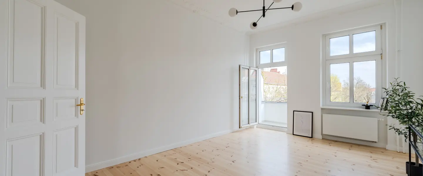 Wohnzimmer mit Fensterfront und Balkonzugang