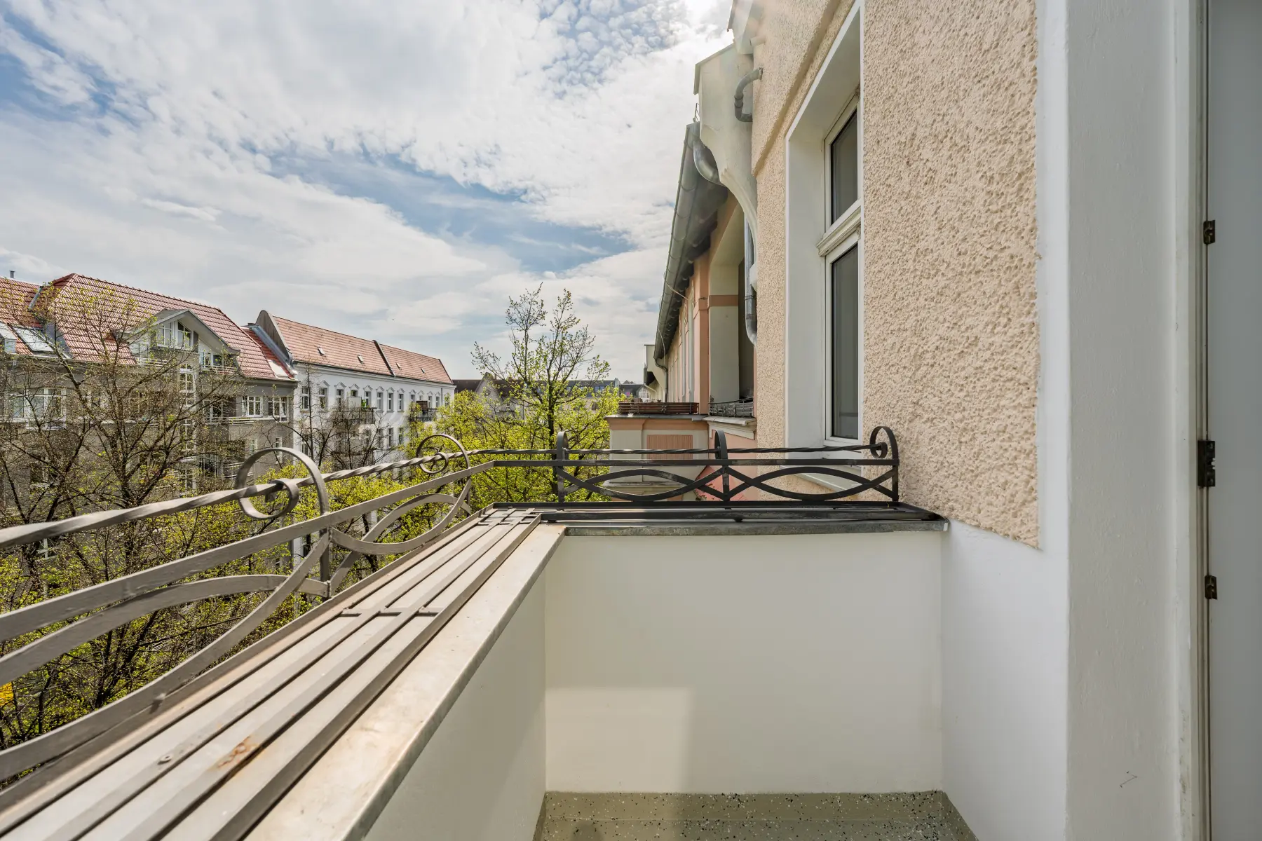Balkon mit Blick in die begrünte Straße
