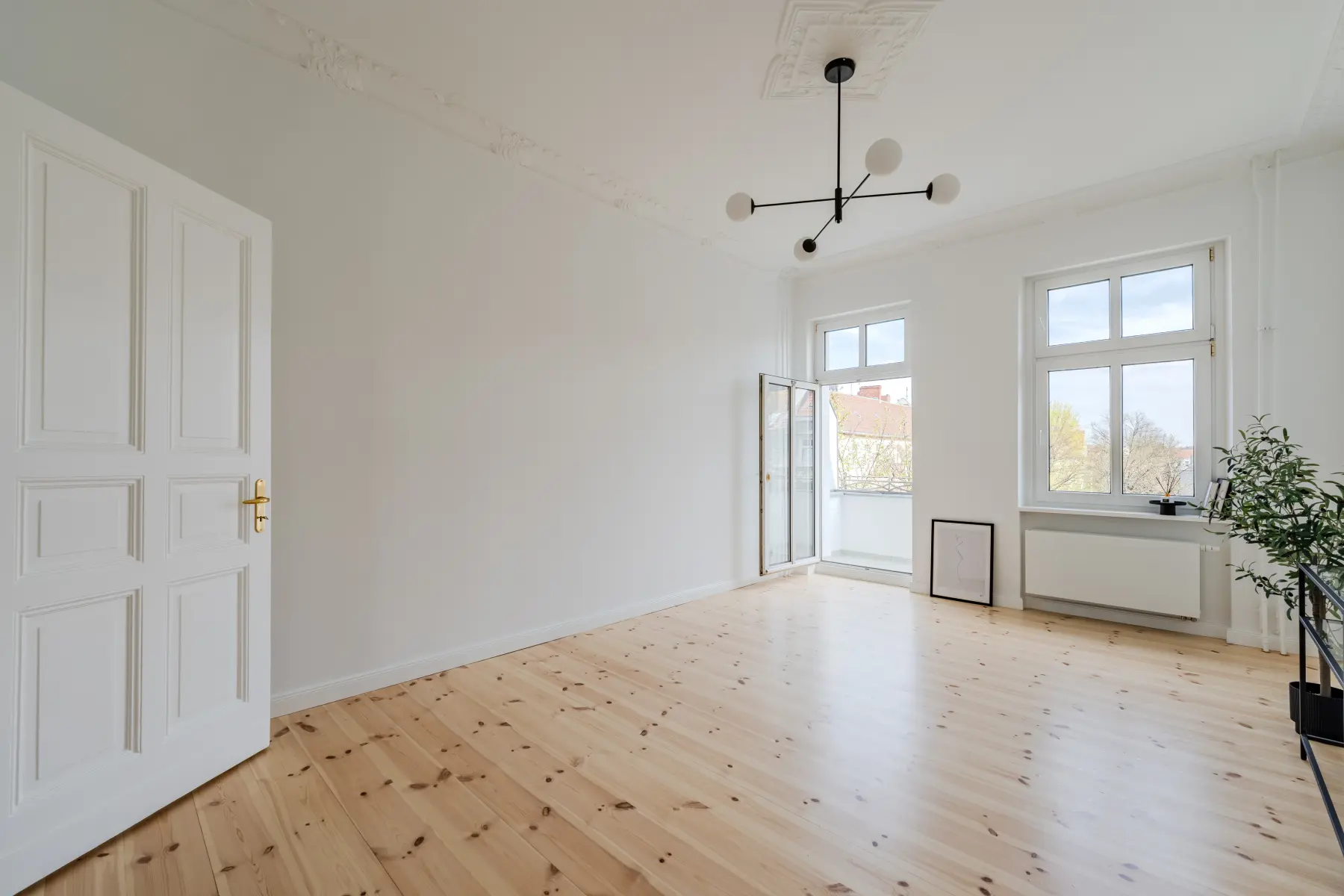 Wohnzimmer mit Fensterfront und Balkonzugang