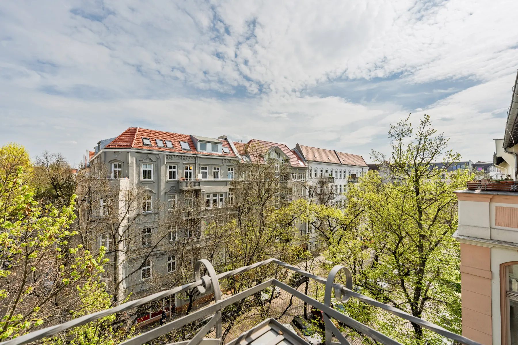Ausblick vom Balkon auf Altbauten und Bäume