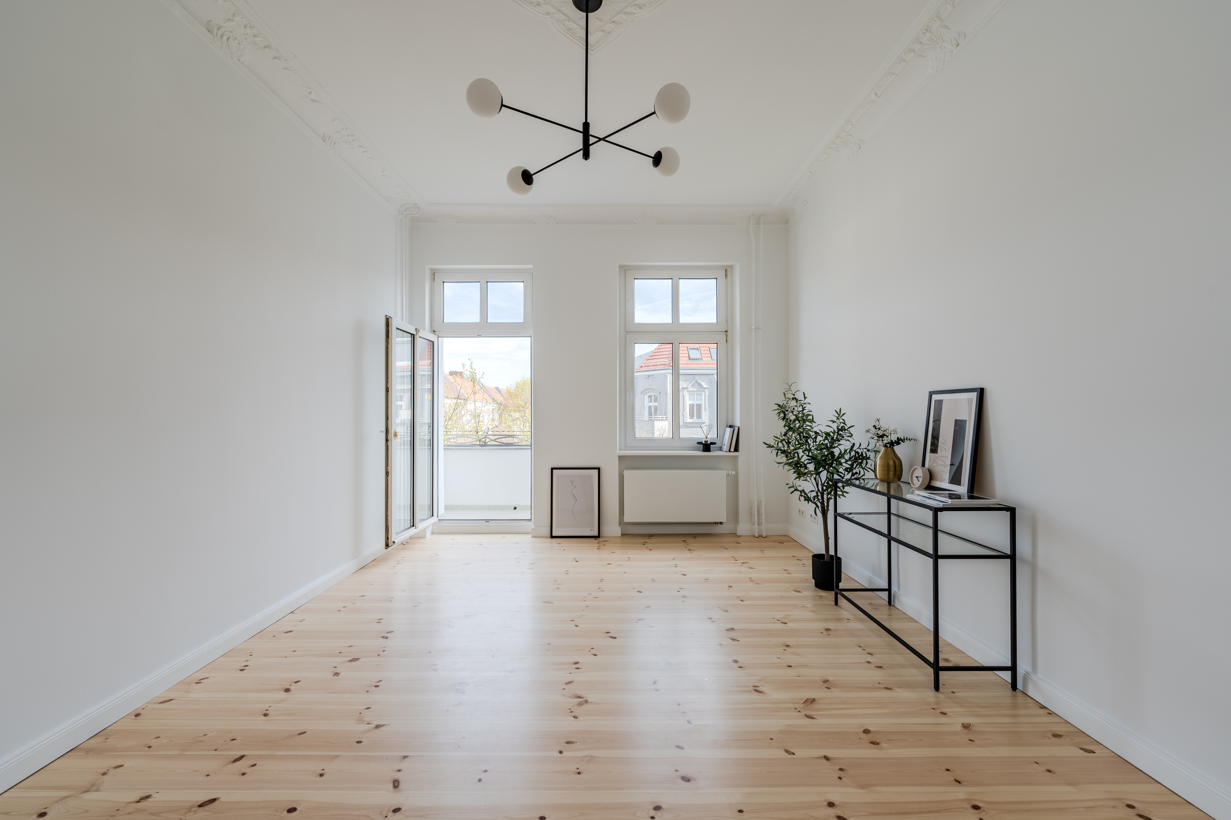 Wohnzimmer mit Balkonzugang und Dielenboden